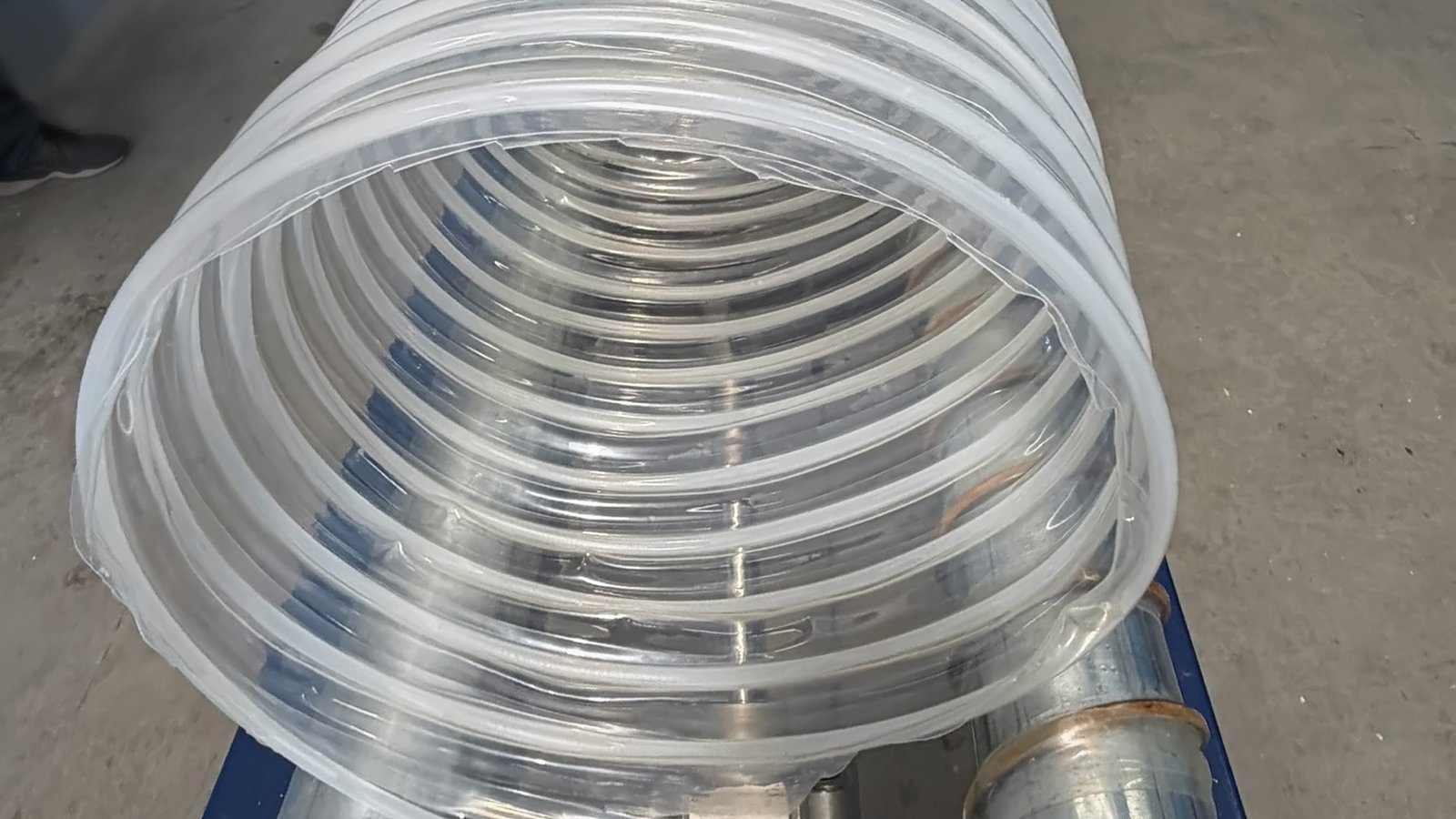 Duto flexível de poliuretano cristal de grande diâmetro com espiral de aço cobreado encapsulada na parede, encaixado em um tubo metálico